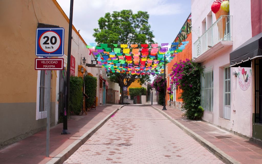 Festive Mexican street in Tequisquiapan with vibrant flags and quaint architecture.