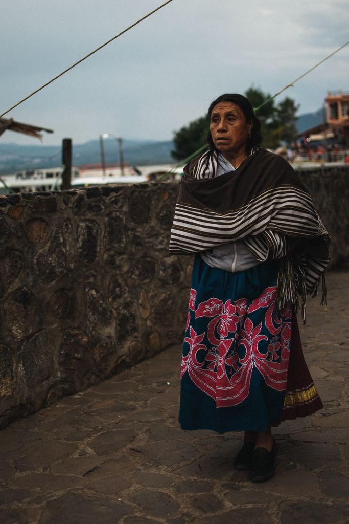 Portrait of an indigenous woman in traditional attire walking in Janitzio, Mexico.